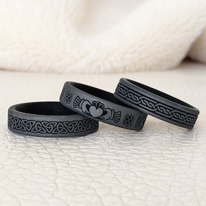 May include: Three gray silicone rings with Celtic knot designs. The center ring features a Celtic knot with a heart in the center.