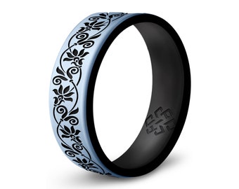 Könnte beinhalten: Ein hellblauer Silikonring mit einem schwarzen Blumenmuster und einem schwarzen Silikonband mit dem eingeprägten Wort "ENGRAVE".