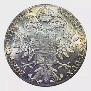Puede incluir: Moneda de plata con un diseño detallado de águila bicéfala, una corona y texto alrededor del borde. La moneda tiene un aspecto desgastado, con signos visibles de edad y uso. El diseño de la moneda incluye un escudo de armas.
