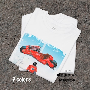 Puede incluir: Camisetas blancas con un gráfico de una motocicleta roja y una persona con una chaqueta naranja. La imagen tiene un fondo azul y blanco. También se ve el texto "7 colores" y "THE OBSIDIAN MIRROR".