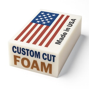 May include: A rectangular block of custom cut foam with the American flag design on top. The flag features red and white stripes and a blue field with white stars. The text "Made in USA" and "CUSTOM CUT FOAM" are printed on the block.