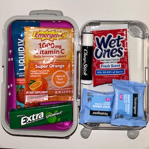 Puede incluir: Un pequeño estuche transparente de viaje con varios productos de salud e higiene. Contenido: sobres de Emergen-C, toallitas antibacterianas Wet Ones, ChapStick, toallitas desmaquillantes Neutrogena, bebida Liquid I.V. y chicle Extra de menta verde.