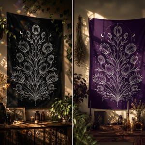 May include: Two wall tapestries, one black and one purple, each with a white illustration of a Venus flytrap plant. The design includes crescent moons and stars. The tapestries are hanging on a wall, with plants and decor in the foreground.