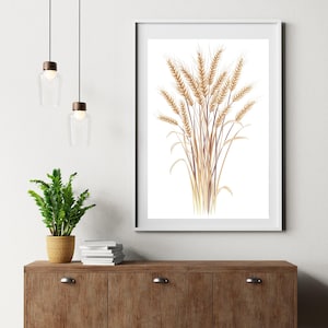 May include: A framed print depicting a detailed illustration of wheat stalks in tan and brown hues against a white backdrop. The artwork is displayed on a wooden cabinet, with a small potted plant and hanging lights in the background.