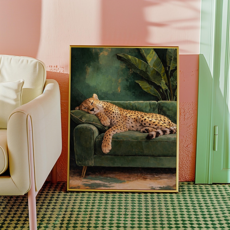 May include: A framed art print depicts a sleeping cheetah on a green velvet sofa. The cheetah has a spotted coat and is resting on a green cushion. The background features a dark green wall and a large plant.