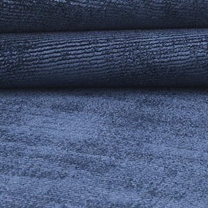 May include: Close-up of a textured, navy blue fabric. The fabric is folded, revealing layers of the material. The texture appears to have a subtle, ribbed pattern, creating a sense of depth and visual interest. The color is a deep, saturated blue.