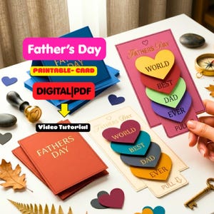 Puede incluir: Una colección de tarjetas de felicitación para el Día del Padre con diseños interactivos de lengüeta y formas de corazón apiladas. Las tarjetas muestran textos como FATHERS DAY, WORLD, BEST, DAD, EVER y PULL. Se utilizan varios colores, incluyendo rosa, rojo, verde, morado, azul, naranja y crema.