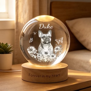 Op de afbeelding: Een bolvormig glazen nachtlampje met een geëtst portret van een Franse Bulldog, de naam Duke en bloemrijke vlindermotieven. De glazen bol rust op een ronde houten voet met de inscriptie Forever in my heart.
