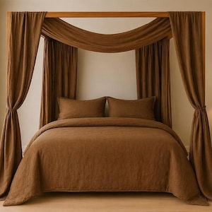 May include: A brown canopy bed with matching bedding and curtains. The bed frame is made of wood, and the curtains are draped around the frame. The room has a neutral color scheme with a lamp on a side table.
