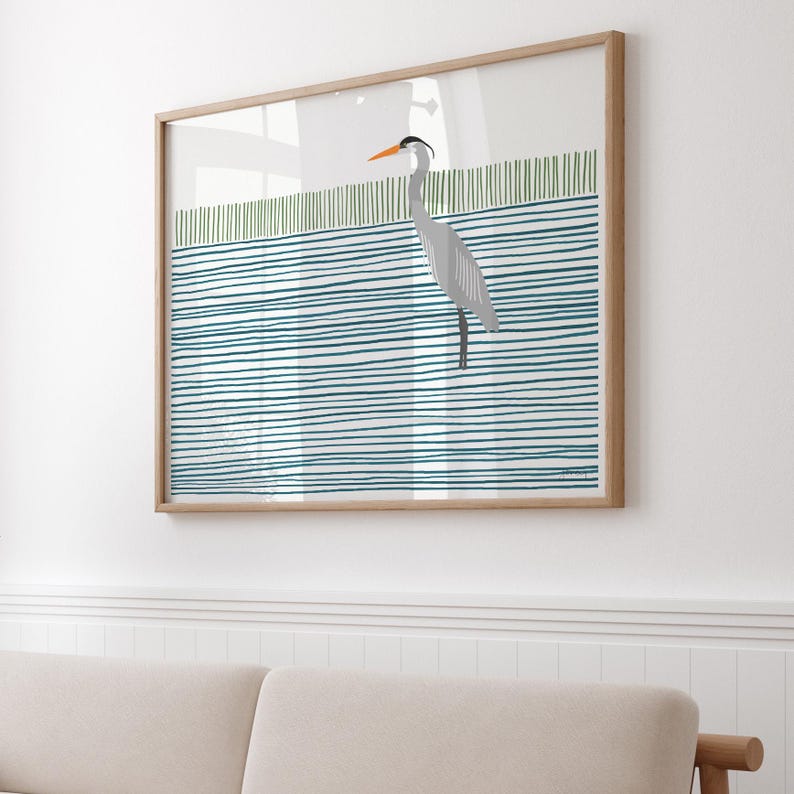 May include: A framed print of a gray heron standing on a blue and green striped background. The heron has an orange beak and is facing to the right.