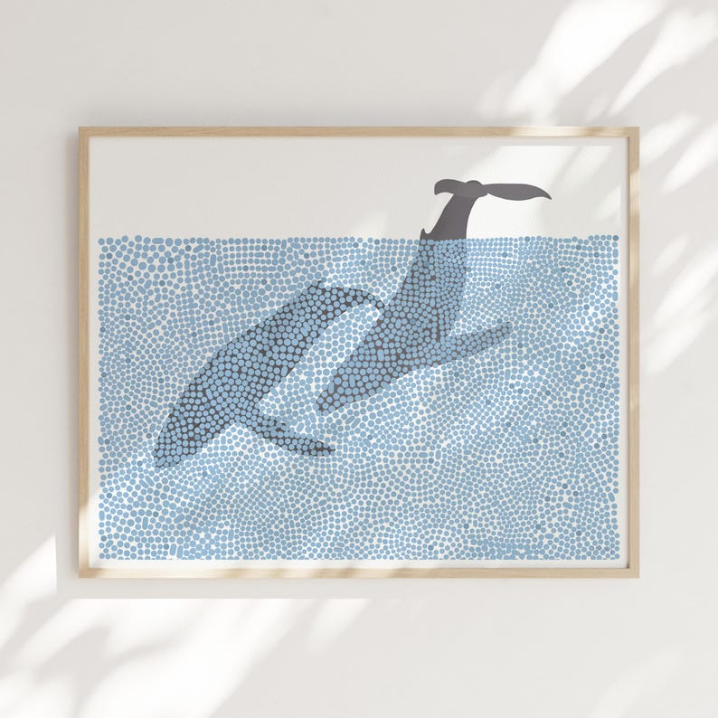 May include: A framed print of two whales swimming in a blue ocean. The whales are made of small blue dots and are outlined in gray. The ocean is also made of small blue dots.