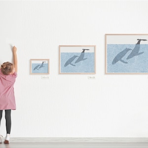 May include: Three framed prints of whales jumping out of the water. The prints are in different sizes, with the largest print measuring 25 x 31 inches. The prints are on a white wall, and a young person is standing in front of them.