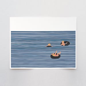 May include: Three people float on inner tubes in a blue and white striped ocean. The people are all wearing swimsuits and have blonde hair. The inner tubes are black.