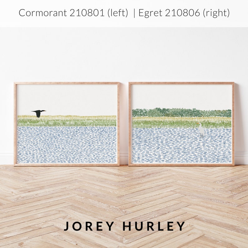 May include: Two framed illustrations of birds in a landscape setting. The left illustration features a black cormorant flying over a blue body of water with green reeds in the background. The right illustration features a white egret standing in a blue body of water with green reeds in the background. The text 'Cormorant 210801 (left) | Egret 210806 (right)' is at the top of the image. The text 'JOREY HURLEY' is at the bottom of the image.