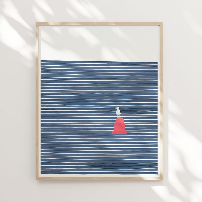 May include: A framed print of a minimalist illustration of a seagull standing on a red buoy in a blue and white striped ocean.