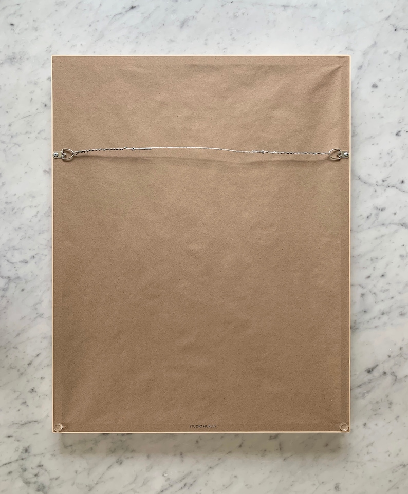 the back of a framed, ready to hang print by artist jorey hurley.  the frame includes a wire across the back for hanging and a kraft paper dust backing to protect the art. felt bumpers are on the bottom corners to protect the wall.