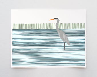 May include: A gray heron with an orange beak stands in a blue and green striped water scene.