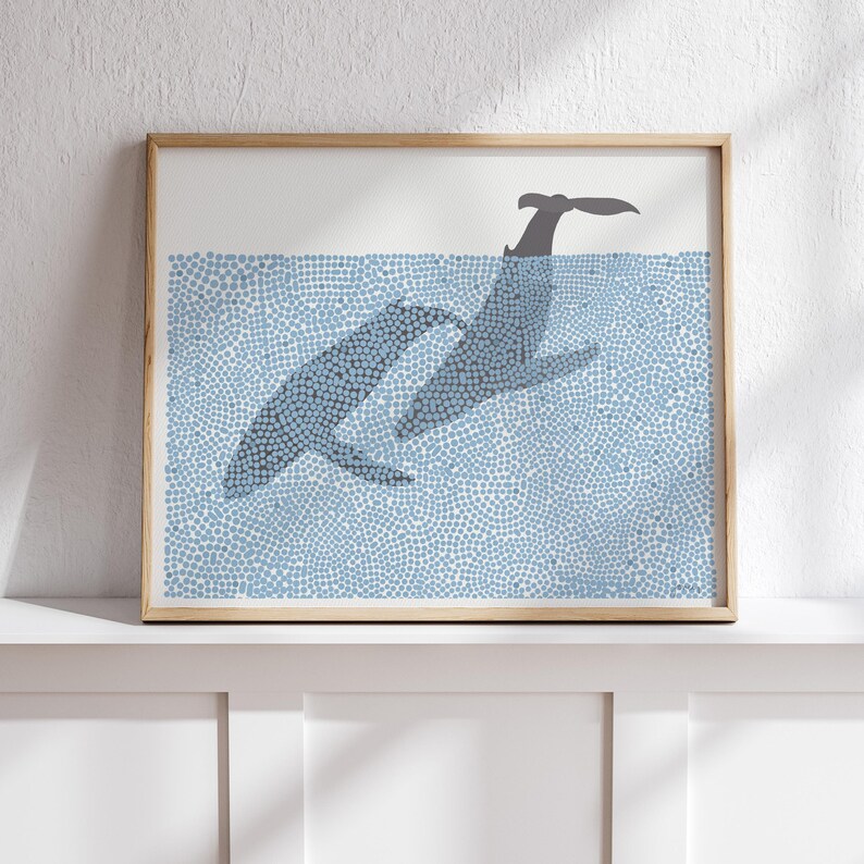 May include: A framed print of two whales swimming in a blue ocean. The whales are made of small blue dots, creating a stippled effect.