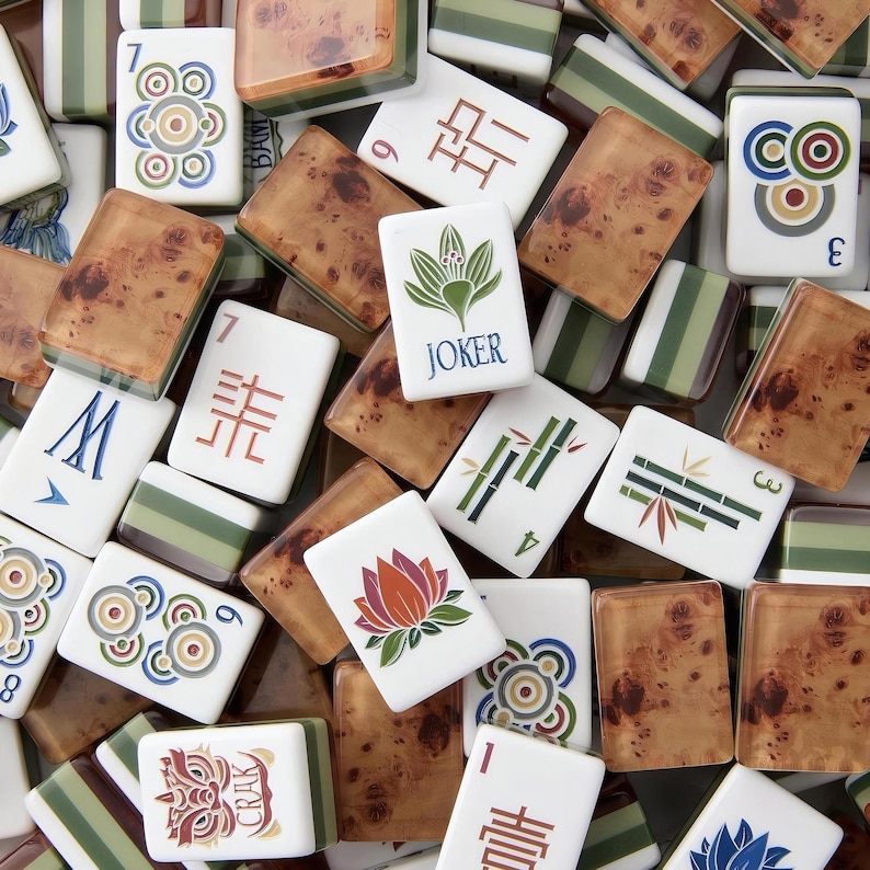 Puede incluir: Una colecci&oacute;n de fichas de Mahjong que presenta una mezcla de fichas blancas con ilustraciones coloridas de flores, bamb&uacute;, c&iacute;rculos y caracteres, junto a fichas con un patr&oacute;n de veta de madera marr&oacute;n y fichas a rayas verdes.