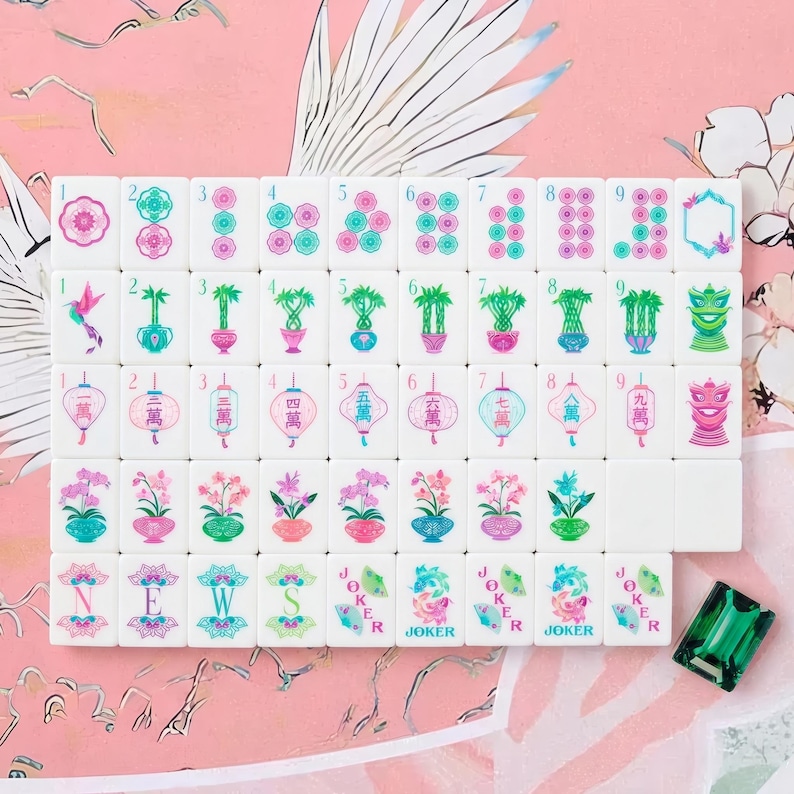 May include: A set of white mahjong tiles featuring colorful floral, bamboo, lantern, and character designs in pink, green, and blue. The tiles include numbered sequences, directional markers, and joker tiles, accompanied by a single green gem tile.