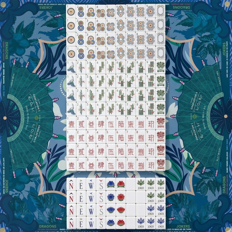 Puede incluir: Un juego de fichas de Mahjong dispuesto sobre una alfombrilla azul con motivos. Las fichas presentan varios palos, incluidos c&iacute;rculos, bamb&uacute;, caracteres, vientos, flores y comodines. La alfombrilla muestra gr&aacute;ficos en abanico y texto.