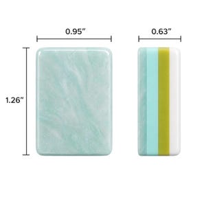 Puede incluir: Un bloque rectangular con una superficie de color verde claro jaspeado que mide 0,95 pulgadas por 1,26 pulgadas. Al lado, una vista lateral muestra rayas verticales en verde claro, turquesa, verde oliva y blanco, con un ancho de 0,63 pulgadas.