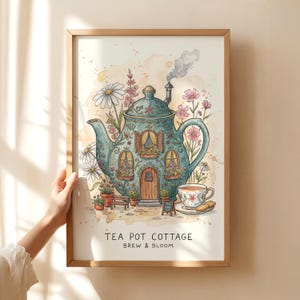 May include: A framed watercolor print titled TEA POT COTTAGE BREW & BLOOM, featuring a teal teapot shaped like a house with windows, a door, and a chimney emitting smoke. It is surrounded by daisies, pink flowers, a small bench, and a teacup with a cookie.