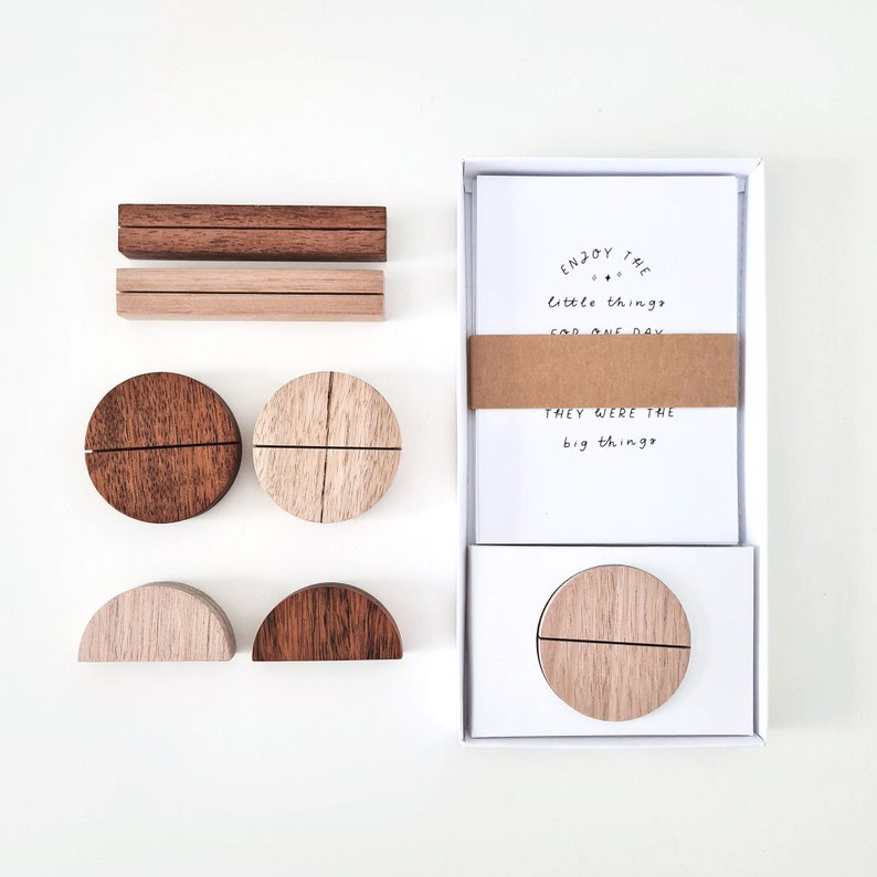 May include: Wooden desk accessories set. Includes two rectangular holders, two circular holders, and two semi-circular holders. A box of cards with the text "Enjoy the little things for one day, they were the big things" is also included.