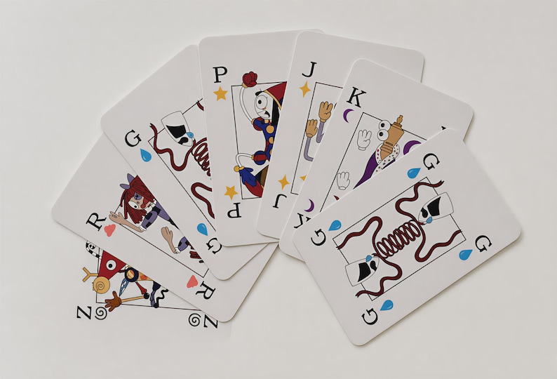 Puede incluir: Un abanico de seis naipes con fondo blanco e ilustraciones de dibujos animados coloridos. Las cartas presentan varios personajes y s&iacute;mbolos, incluidas las letras G, P, J, K, R y Z, junto con peque&ntilde;os iconos de gotas azules y estrellas amarillas.