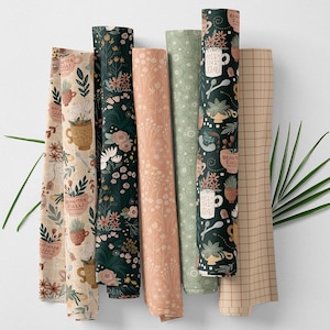 Könnte beinhalten: Gerollte Stoffballen mit verschiedenen floralen und botanischen Mustern. Designs umfassen Blumen, Pflanzen und Teetassen mit dem Text "BEAUTEA FULL!" und "POSITIVI-TEA". Farben sind Grün, Rosa, Beige und Braun.