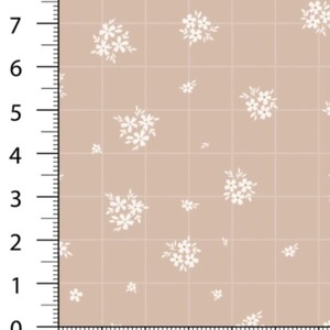 May include: Tan fabric with a grid pattern and scattered white floral clusters. The grid is marked with measurements in inches, with numbers from 0 to 8 along the left edge and 0 to 6 along the bottom edge.