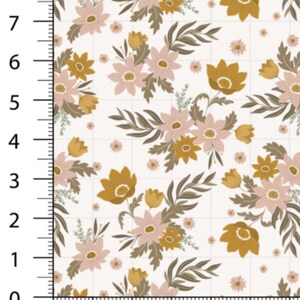May include: Floral fabric with a repeating pattern of stylized flowers and leaves in shades of gold, pink, and brown on a white background. The fabric is marked with a grid and a ruler showing measurements in inches.