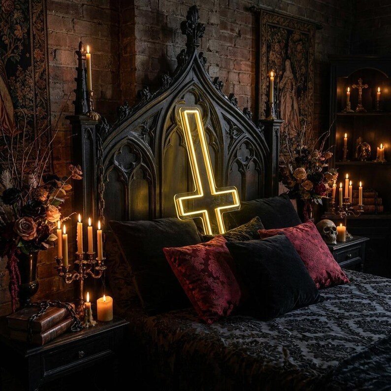 May include: A gothic-style bedroom with a black bed frame and a neon yellow inverted cross. The bed is adorned with black and red velvet pillows and a patterned comforter. Lit candles and floral arrangements add to the dark aesthetic.
