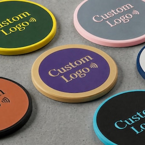May include: A collection of round coasters in various colors, each featuring the text "Custom Logo" and a wireless symbol. Colors include green with yellow trim, orange with black trim, and blue with white text.