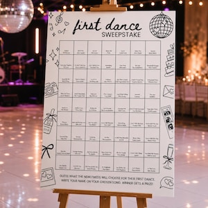 Könnte beinhalten: Ein weißes rechteckiges Schild auf einer Holzstaffelei mit der Aufschrift first dance SWEEPSTAKE. Das Schild zeigt ein Raster mit Songtiteln und Künstlernamen, umgeben von schwarzen Strichzeichnungen einer Discokugel, einer Kamera, einer Torte und einer Champagnerflasche.