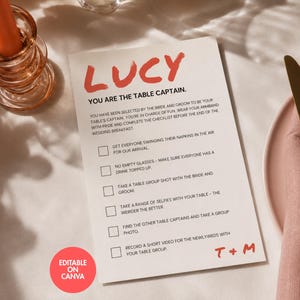 May include: A white rectangular card with red text reading LUCY and T+M, featuring the heading YOU ARE THE TABLE CAPTAIN and a checklist of wedding tasks. The card includes a red circular badge that reads EDITABLE ON CANVA in white text.