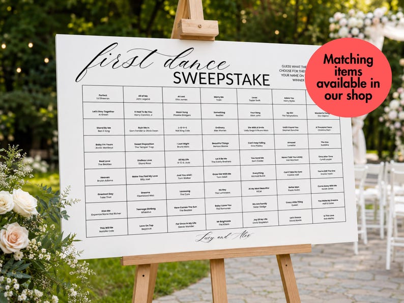 May include: A white rectangular wedding sign on a wooden easel featuring the text first dance SWEEPSTAKE and a grid of song titles and artist names. The sign includes instructions to guess the song and write a name, with the names Lucy and Alex at the bottom.