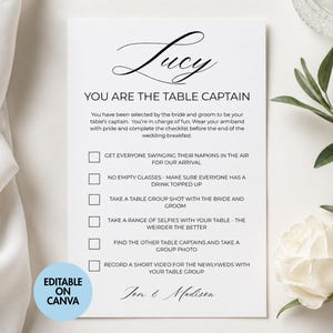 Op de afbeelding: Een witte checklist voor de tafelhoofdman van een bruiloft met de naam "Lucy" in sierlijke letters. De checklist bevat taken zoals het maken van selfies en het opnemen van een video. De zin "Editable on Canva" staat in een blauwe cirkel.