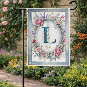 Peut inclure: Un drapeau de jardin avec un motif floral comprenant des roses roses, des tulipes et des papillons. Le drapeau a une bordure bleue et un ovale central avec la lettre "L" et le nom "Luna".
