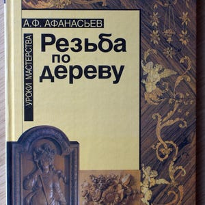 Könnte beinhalten: Ein Buch mit dem Titel "Rezba po derevu" mit russischem Text. Das Cover hat einen gelben Hintergrund mit dekorativen Holzschnitzereien und dem Namen des Autors. Das Thema des Buches ist Holzbearbeitung und Schnitzen.