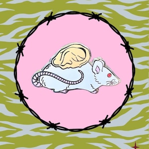 May include: A whimsical enamel pin featuring a white mouse with a tan wing, red eye, and a pink tail, set against a pink circle and surrounded by a barbed wire design. The background has a green and gray zebra stripe pattern.