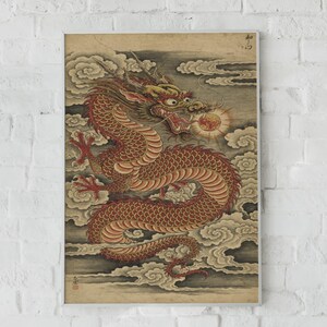 May include: A rectangular wall art print featuring a detailed illustration of a red and gold dragon winding through stylized grey clouds. The dragon has an open mouth and is positioned near a glowing orange orb. Japanese characters appear in the corner.
