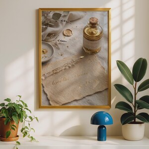 May include: A framed wall art print featuring a glass dip pen resting on textured paper with the handwritten text 'breathe create inspire'. Beside it sits a glass bottle with a cork stopper, a small ceramic dish, and a wax seal on fabric.
