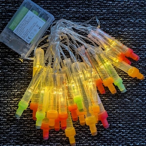 Könnte beinhalten: Eine weiße Keramik-Tasse mit schwarzem Henkel und dem Text "But First, Coffee" in schwarzer, handschriftlicher Schrift. Die Tasse steht auf einer weißen Oberfläche.