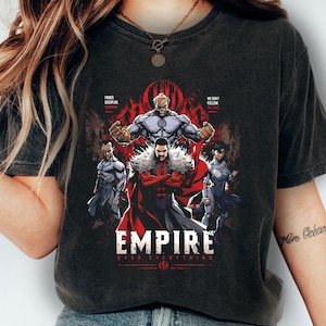 May include: Dark gray t-shirt featuring a graphic of a group of comic book characters. The design includes the word "EMPIRE" in white, with the phrase "OVER EVERYTHING" below it. The characters are in shades of gray, red, and black.