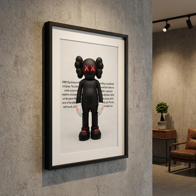 May include: Framed artwork featuring a black KAWS figure with red 'XX' eyes and red accents on its feet. The figure has white gloves and is set against a white background. The black frame is mounted on a gray textured wall.