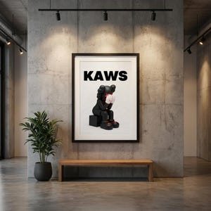 May include: A framed artwork featuring the word "KAWS" above a black figure with pink hands and feet. The artwork is displayed on a concrete wall above a wooden bench, with a potted plant to the left.