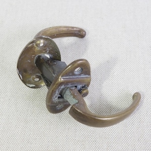 May include: Antique brass door handle with two levers. The handle has a decorative design and is in good condition.