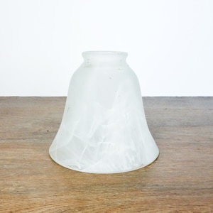 May include: A white frosted glass lampshade with a bell shape and a textured surface.