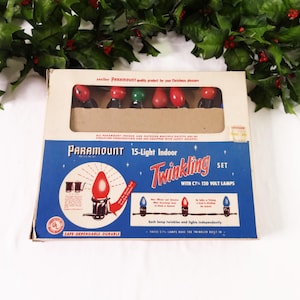 May include: Vintage Paramount 15-Light Indoor Twinkling Set with C7 120 Volt Lamps. The box features a blue and white design with red, green, and red Christmas light bulbs. The text on the box reads "SAFE-DEPENDABLE-DURABLE."
